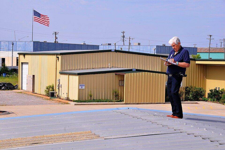 Inspector documenting a hail-damaged roof